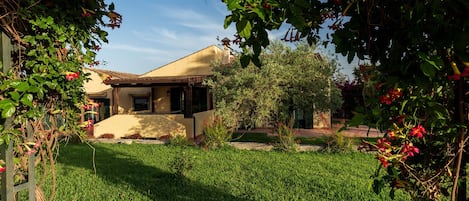 The villa immersed in the greenery of the garden
