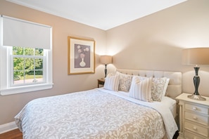 Master queen bed, clean linens, bedside lighting, wardrobe and window shade.