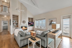 Tall ceilings and a fireplace flank this cozy family room with great views!