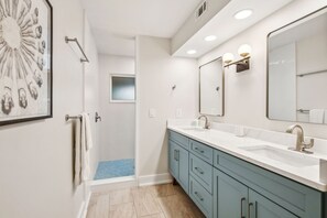 Master Bathroom with Tiled Walk In Shower, Double Vanities, and a Private Water Closet