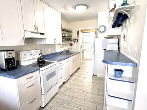 Fully stocked kitchen with all essentials plus a dishwasher. Bathroom through the doorway at the end.