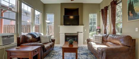 Leather comfort, gas fireplace, and ceiling fan - a living room for all seasons.