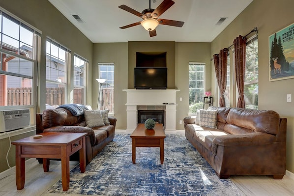 Leather comfort, gas fireplace, and ceiling fan - a living room for all seasons.