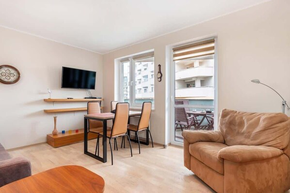 Living room with TV, sofa bed and exit to balcony.