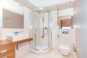 Bathroom with a shower, toilet, sink, mirror and hair dryer.