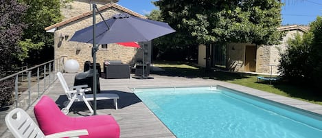 La piscine avec sa grande terrasse en bois de 70 m2 avec vue sur le vallon.