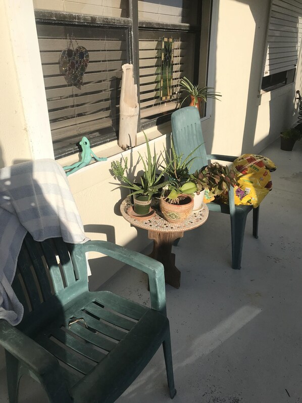 Front patio at the entry way of the condo. 2 chairs and a table. 