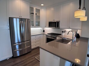 Gourmet Chef's Kitchen: quartz countertops and premium KitchenAid appliances.