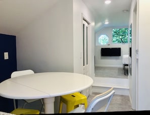 Kitchenette with counter-height drop-leaf table and 4 bar stools / chairs.