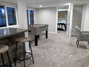 Game room with wet bar and tv access to lake level patio