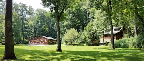 View of cabin and barn from field/riverfront area