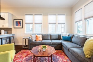 Comfortable sofa couch and custom blinds allow for guests to actually enjoy sleeping in the living room 