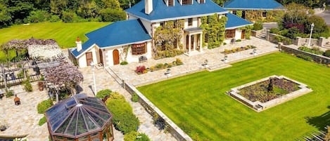 Aerial view of home, patio with summer home, and fire pit