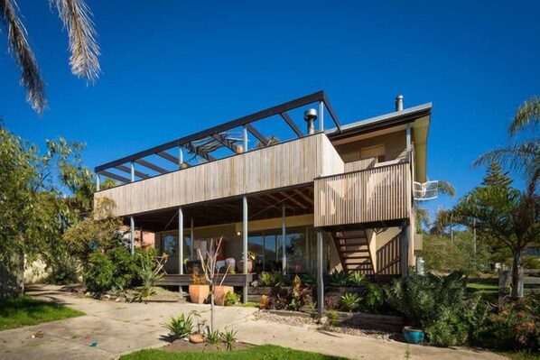 Top deck with sea views and back lane access BBQ area and outdoor setting . 