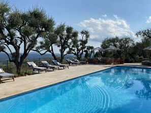 Large south facing pool with sun loungers, sofas and boule area.