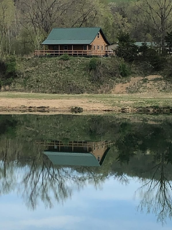 Refection of cabin seen in lake.