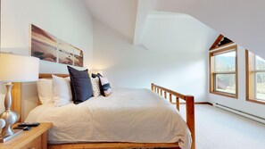 Upstairs primary bedroom w/ king-sized bed and cable TV