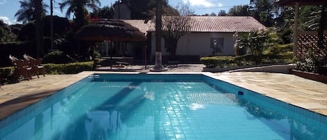 VISTA DA PISCINA. CASA PRINCIPAL AO FUNDO.