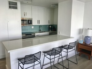 Remodeled kitchen with quartz counters and stainless appliances.