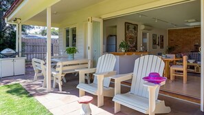 Covered area with table and seating, garden area and Gas BBQ.