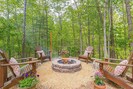 A stocked fire pit with Adirondack chairs.