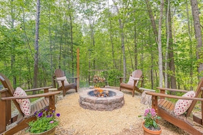 🌳Backyard - A stocked fire pit with Adirondack chairs.