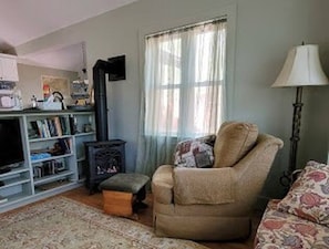 Another view of living room facing TV, gas logs and kitchen