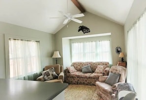 Cozy living room, facing TV, gas log stove and kitchen