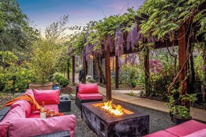 beautiful walkway underneath trellis and sitting area with fire pit (near the office)