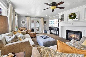 A bright and beautiful family room greets our guests with an open floor plan leading into the dining room and kitchen. French doors, recently added to access the new deck, hot tub and fire table.