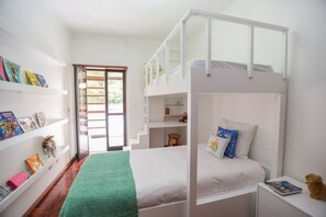 Quarto com beliche e gavetão e armário.