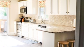 Remodeled kitchen has stunning quartz countertops and stainless steel appliances