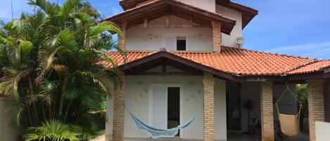 Fachada dos fundos vista da piscina,
Rede e cadeira de balanço 