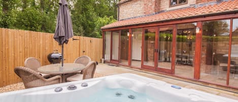 Enclosed garden with outside dining furniture, bbq and hot tub