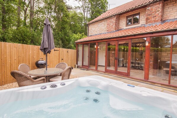 Enclosed garden with outside dining furniture, bbq and hot tub