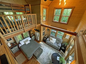 Cozy queen bed and twin bunk beds in the loft, accessible by ladder. 