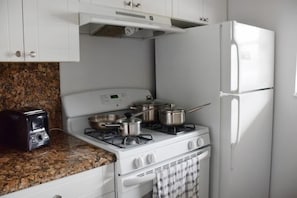 Fully equipped kitchen with a microwave, stove, oven and fridge. All utensils, plates and glasses are provided