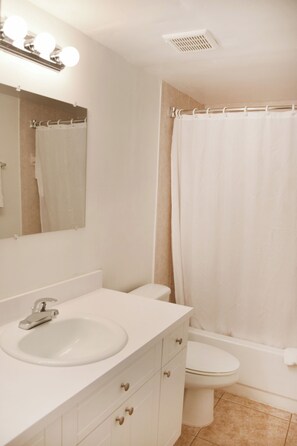 Bathroom with a shower and tub. The essential kit and towels are provided!