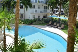 Large swimming pool with poolside loungers and umbrellas