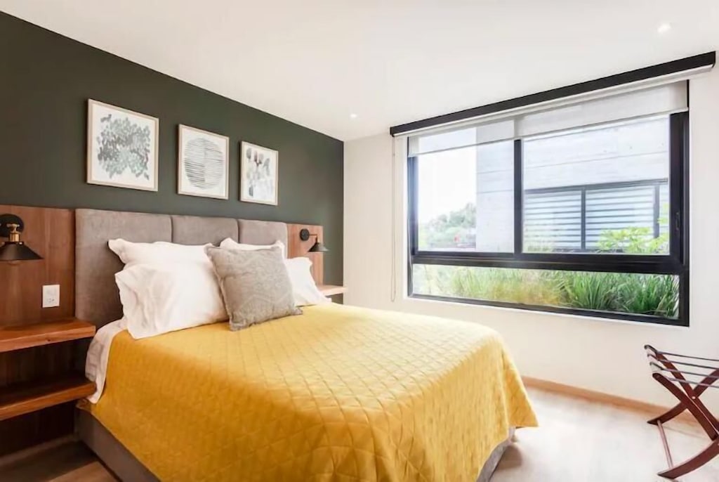 VRBO Mexico City: Bedroom with large window and yellow blanket on the bed
