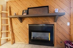 A close-up shot of the unique, wood-paneled gas fireplace where you can warm up after a day exploring Breckenridge, thanks to this home’s fantastic location in the heart of Breckenridge.