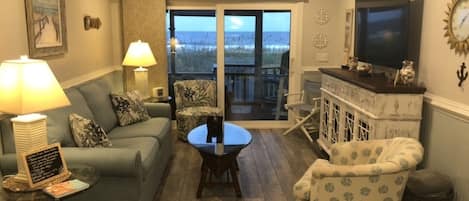 Living room leading to the screened in patio. Open  slider ocean sounds calling.