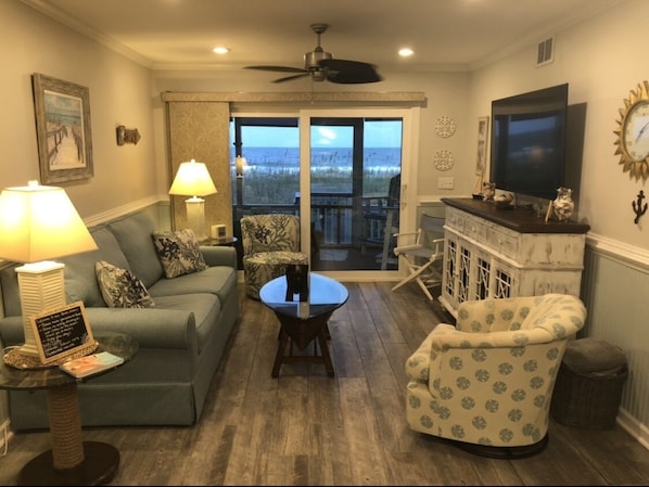 Living room leading to the screened in patio. Open  slider ocean sounds calling.