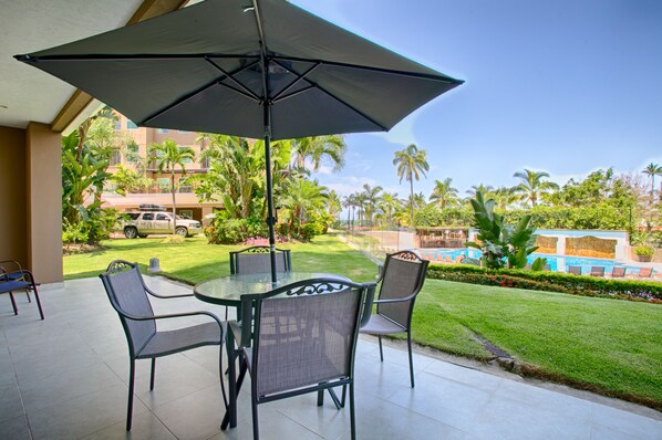 Large private patio overlooking pool, lush gardens