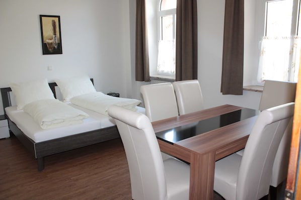 Ferienwohnung EG: Wohn- und Schlafzimmer mit Esstisch, TV und Doppelbett