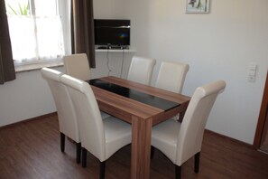 Ferienwohnung EG: Wohn- und Schlafzimmer mit Esstisch, TV und Doppelbett
