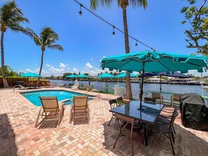 The back patio with big 8 seater tables, 2 BBQ's  umbrellas and sun loungers