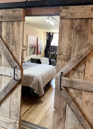 Large master bedroom behind barn doors, with its own living/dining area. 