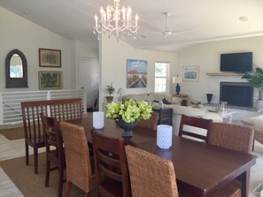 dining and upstairs living room,  with tv over fireplace, stairs to lower level