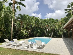 Grande piscine sécurisée avec un beau jardin tropical